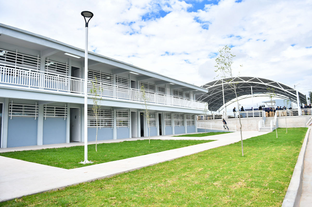 Edificio de dos niveles y plaza cívica con velaria del nuevo bachillerato en El Reencuentro